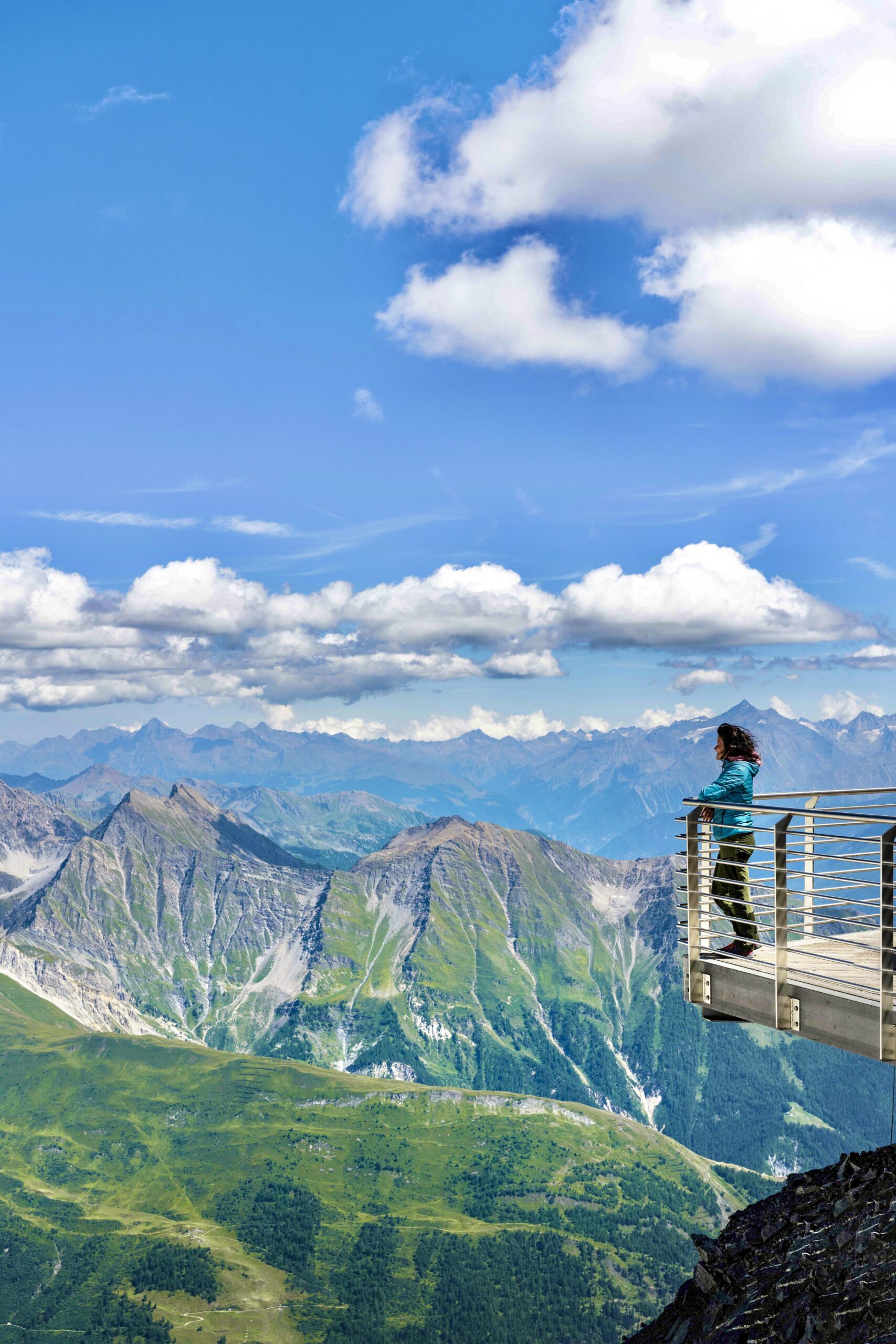Donna che osserva il panorama infinito di vette alpine da una delle terrazze di Skyway Monte Bianco, Valle d'Aosta
